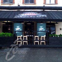 Летняя терраса у петербургского кафе. Деревянный каркас, 
черного цвета, пвх крыша с символикой кафе.